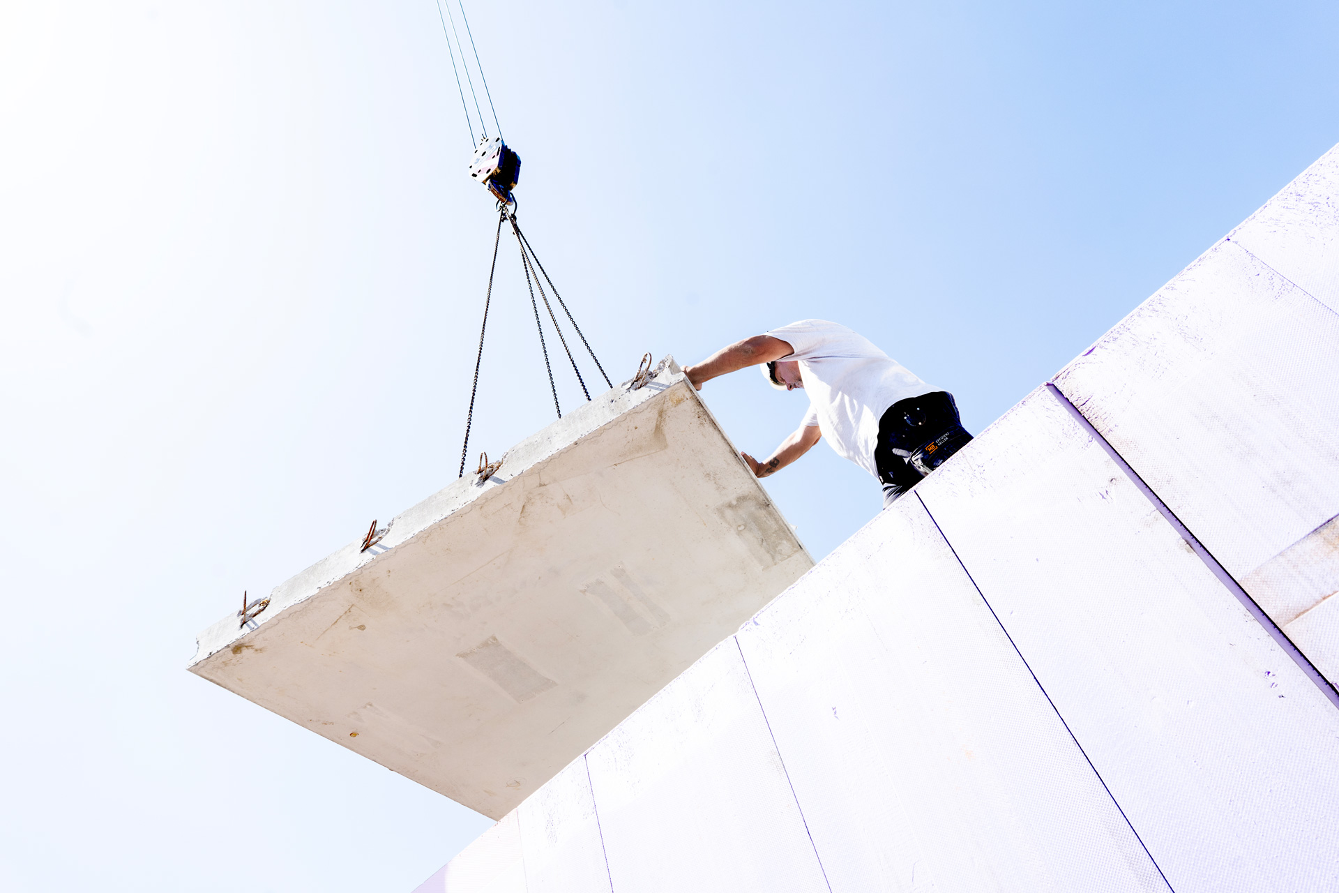 Mitarbeiter beim Versetzen eines Betonelements auf der Baustelle – Karriere bei MB-Keller im Bereich Fertigkellerbau mit Zukunftsperspektive