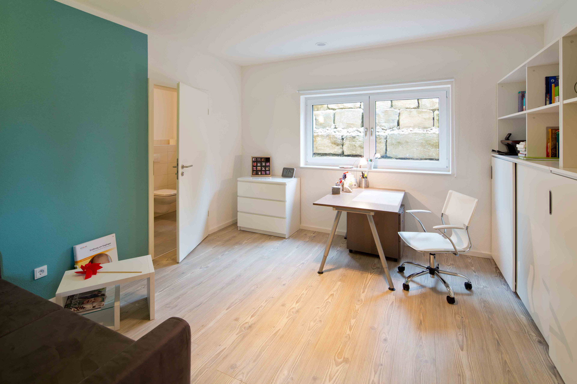 Helles Arbeitszimmer im MB-Keller mit Fenster, Schreibtisch und Bücherregal als zusätzlicher Wohn- und Arbeitsraum
