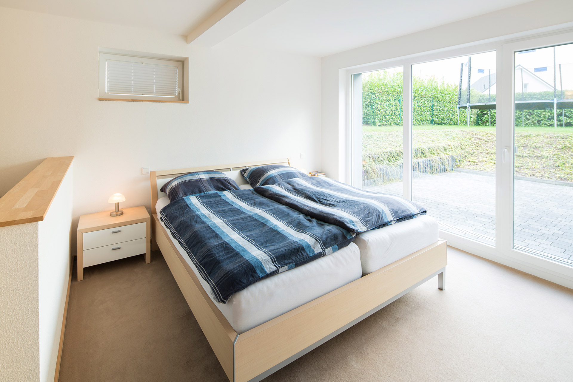 Gemütlicher Wohnbereich mit Schlafzimmer im MB-Fertigkeller, große Fenster sorgen für Tageslicht und Wohlfühlatmosphäre